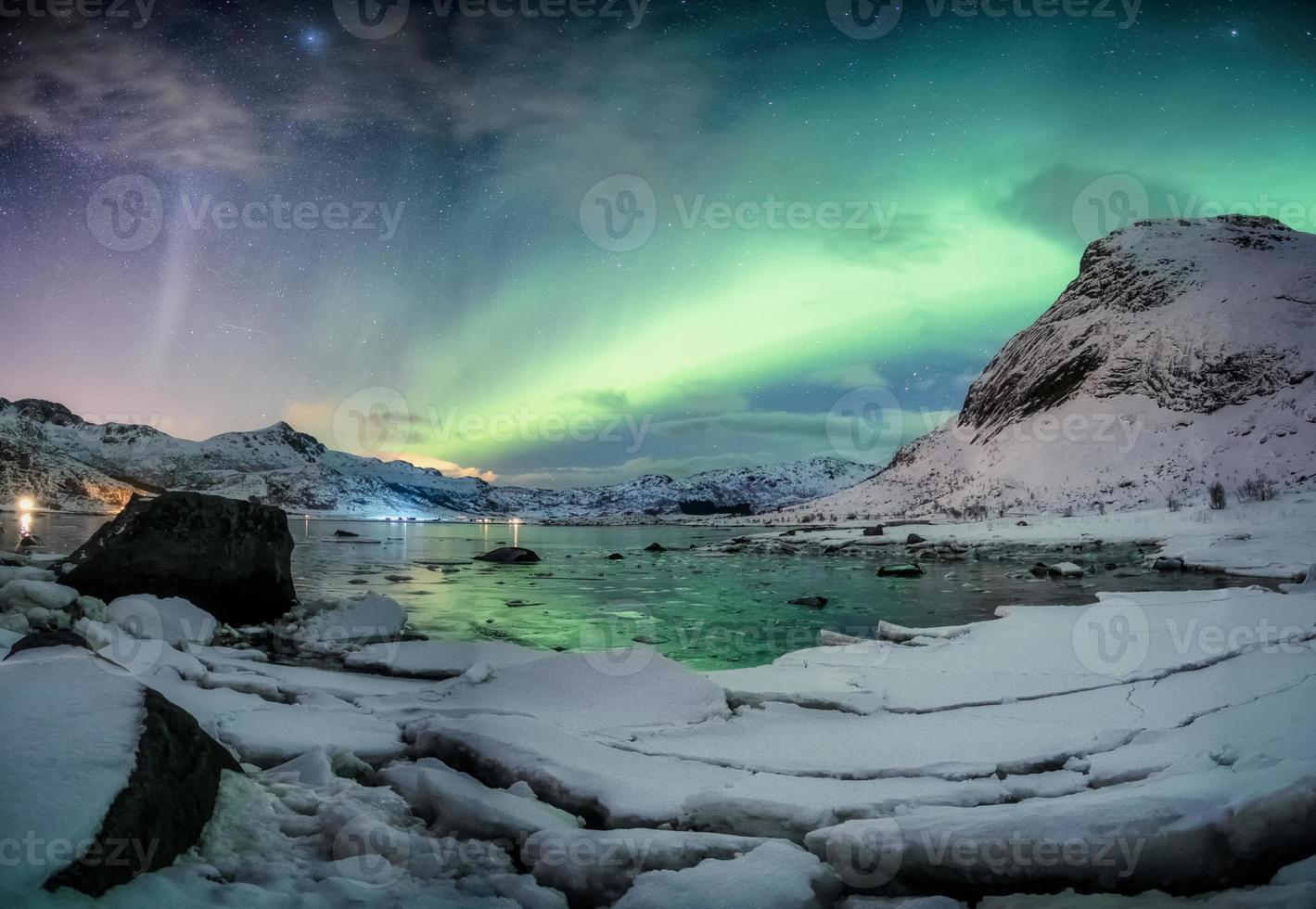 esplosione dell'aurora boreale sulla catena montuosa innevata foto