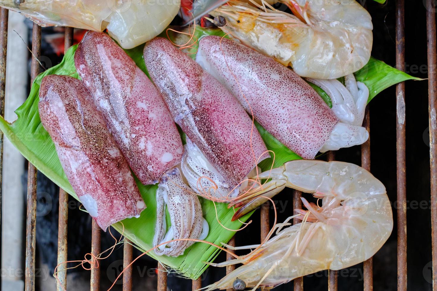 frutti di mare freschi come gamberetti, calamari e pesce sono tradizionalmente arrostiti da foglie di banana avvolte su una griglia a carbone affumicato. è una cena deliziosa per feste barbecue, picnic o pasti al ristorante. foto