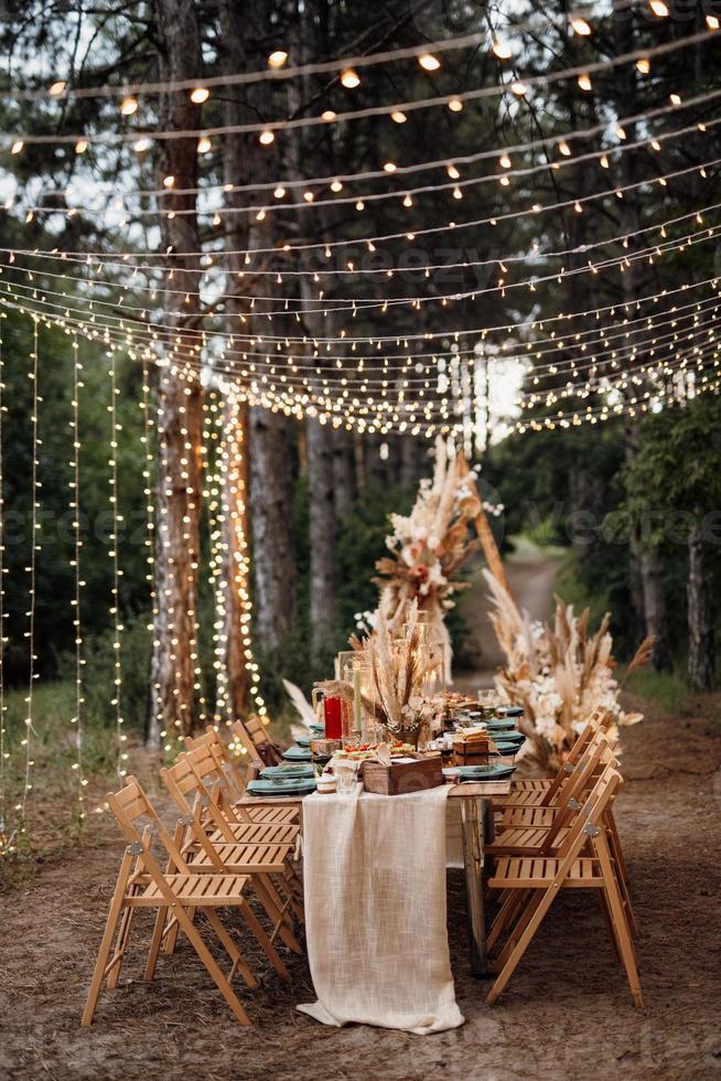 area per banchetti nuziali in una pineta con un arco sullo sfondo foto