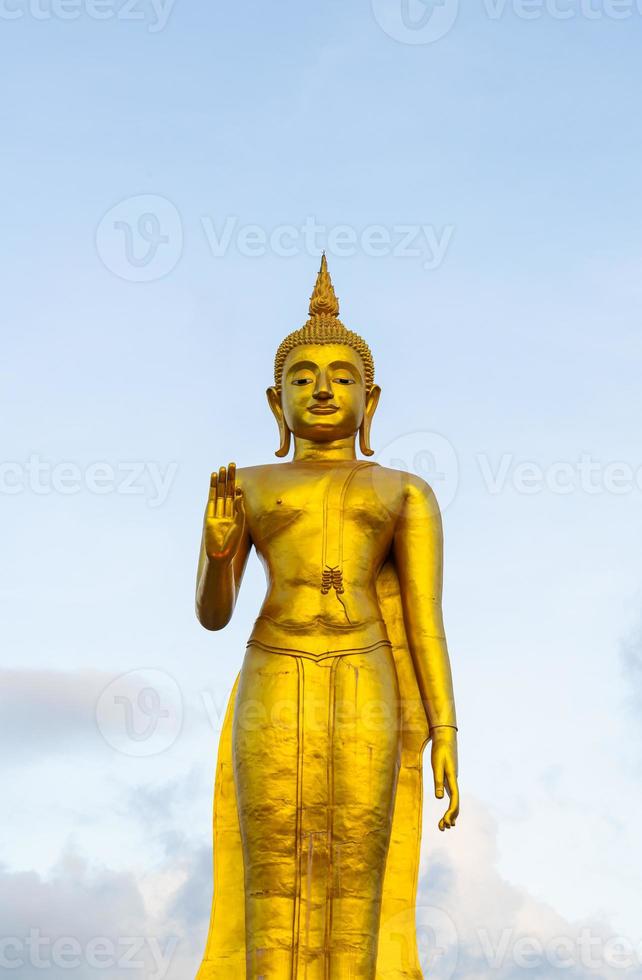 Una statua dorata del Buddha con il cielo sulla cima della montagna al parco pubblico del comune di Hat Yai, provincia di Songkhla, Thailandia foto