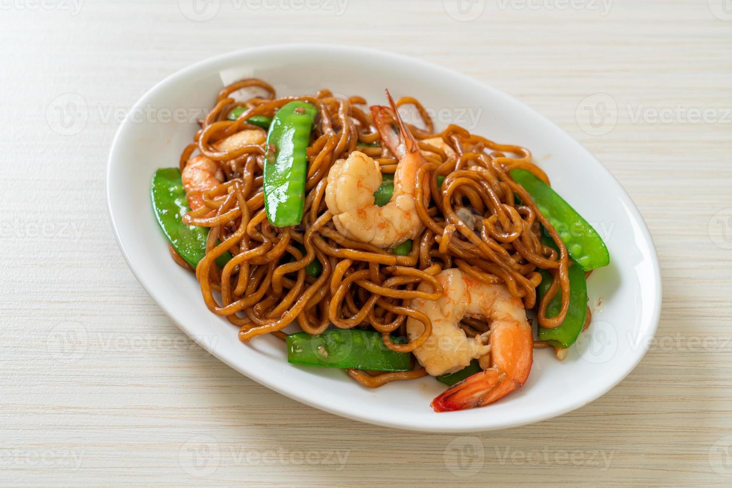 noodles yakisoba saltati in padella con piselli e gamberi - stile asiatico food foto