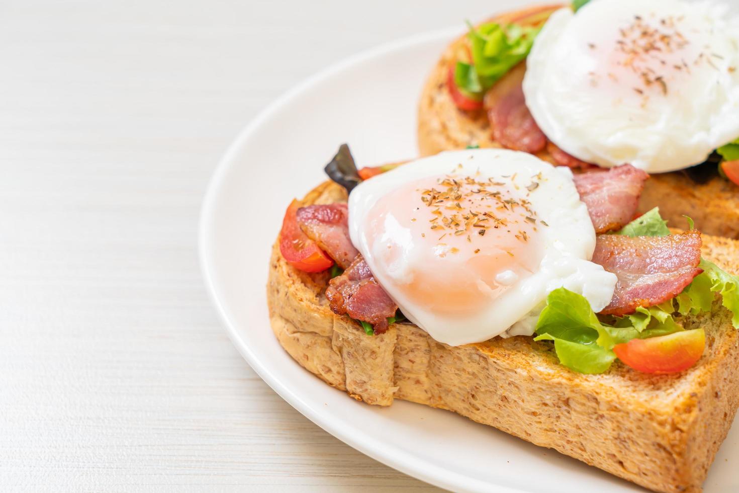 pane integrale tostato con verdure, pancetta e uovo o uovo alla benedict, per colazione foto