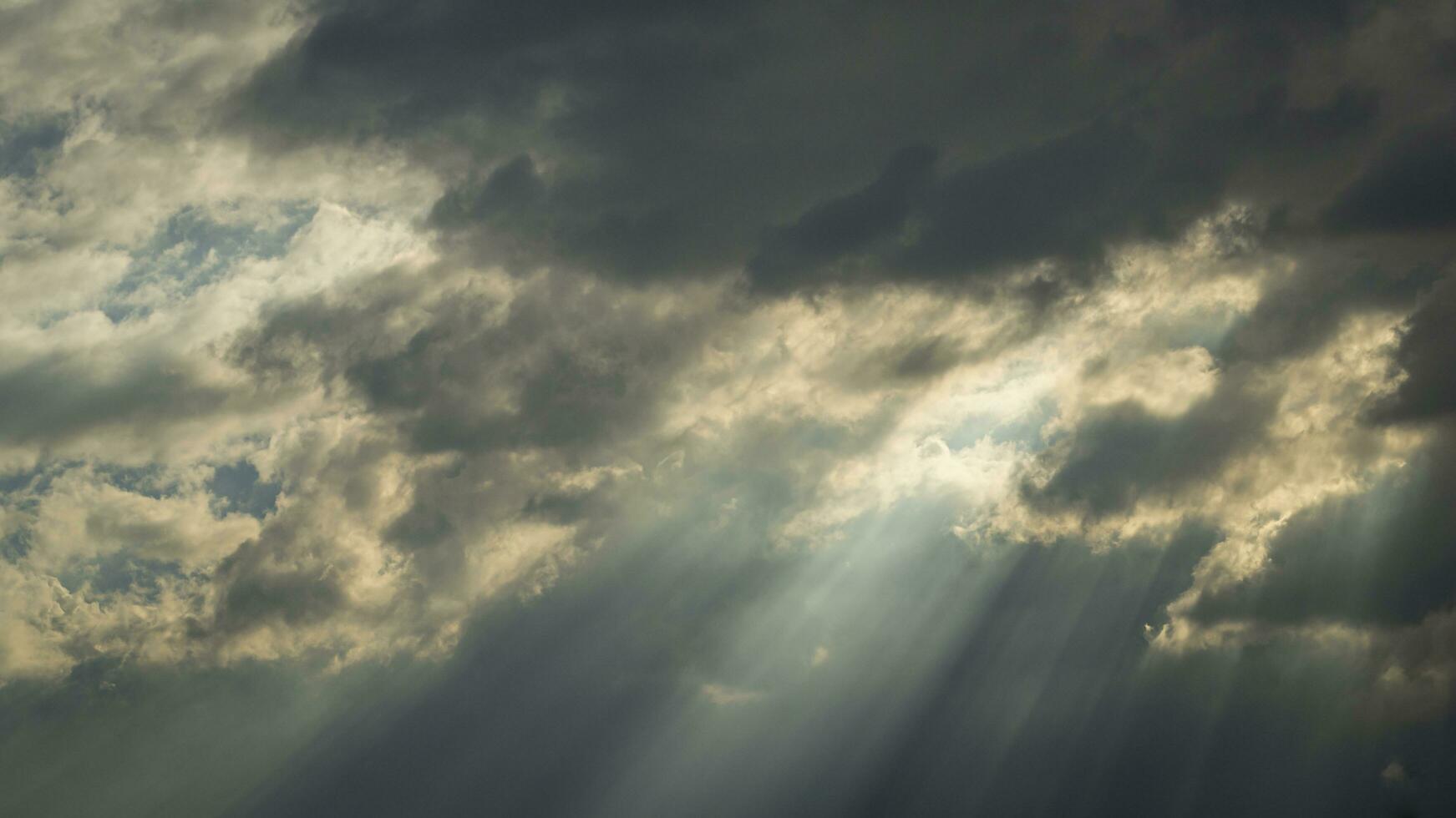 un' nuvoloso cielo con sole raggi foto