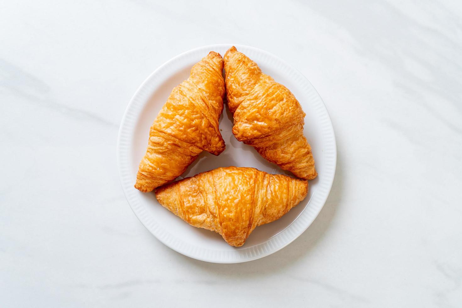 croissant al burro fresco nel piatto foto