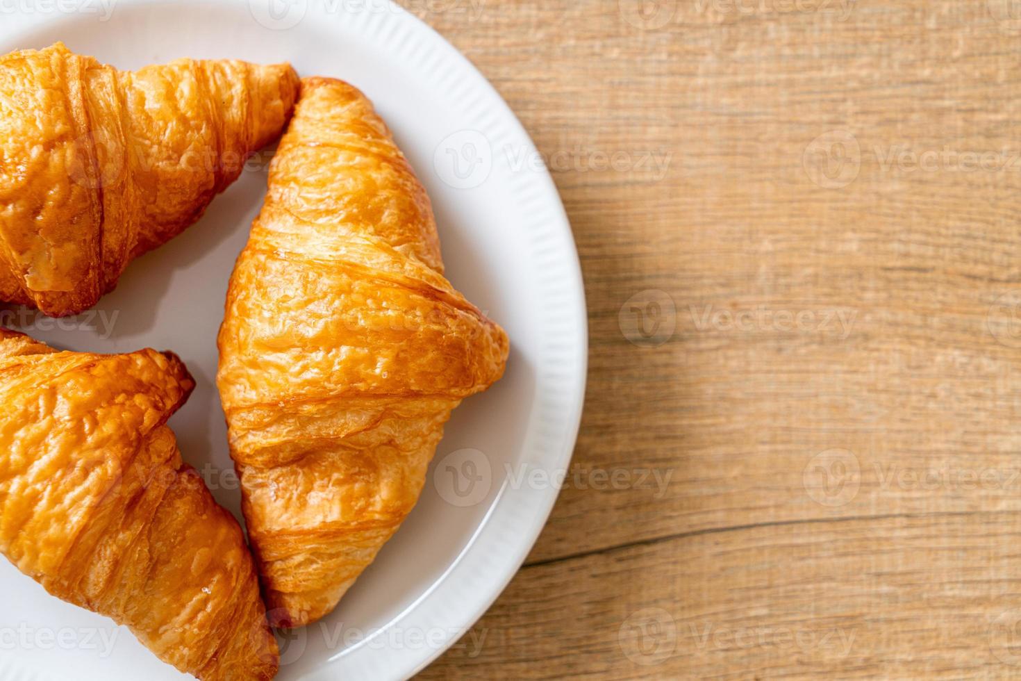 croissant al burro fresco nel piatto foto