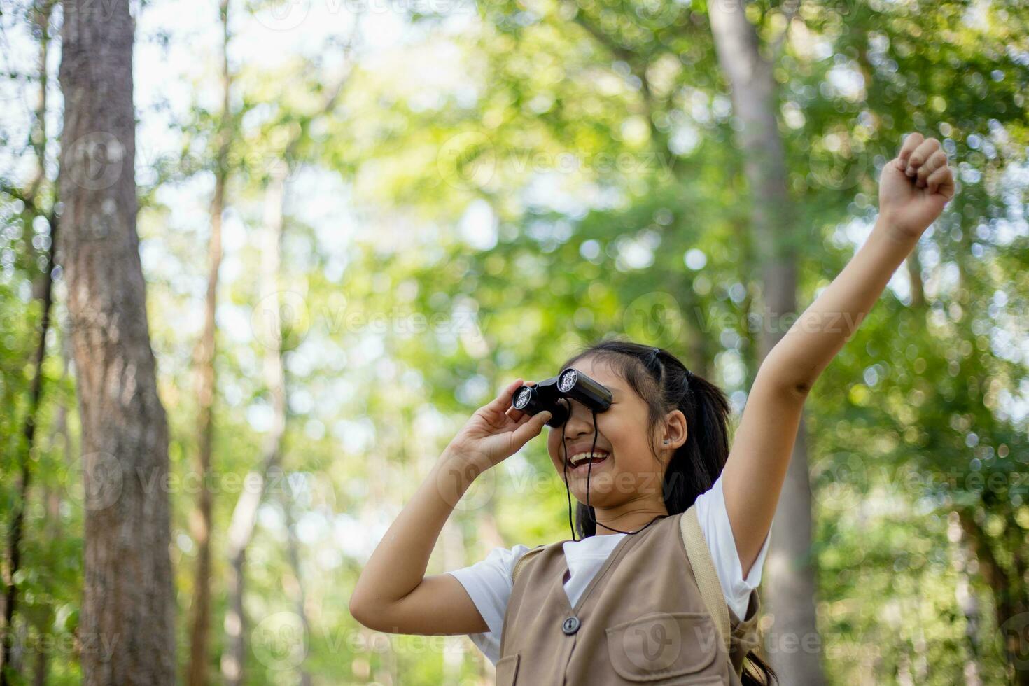 contento poco asiatico ragazze guardare avanti e sorridente bambino con il binocolo nel il parco. viaggio e avventura concetto. libertà, vacanza foto