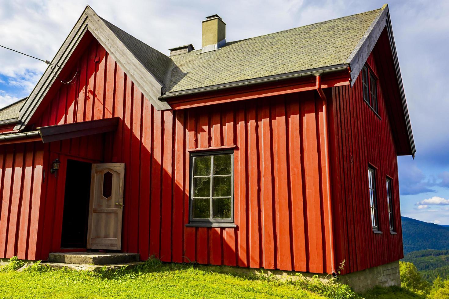 bella capanna di legno rossa della cabina sulla collina nella natura della norvegia. foto