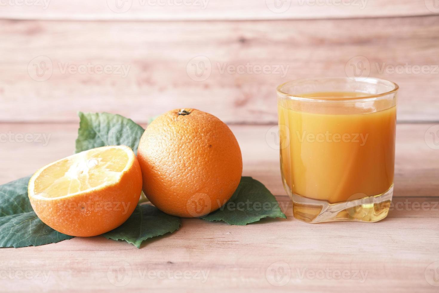 bicchiere di succo d'arancia e arancia sul tavolo foto