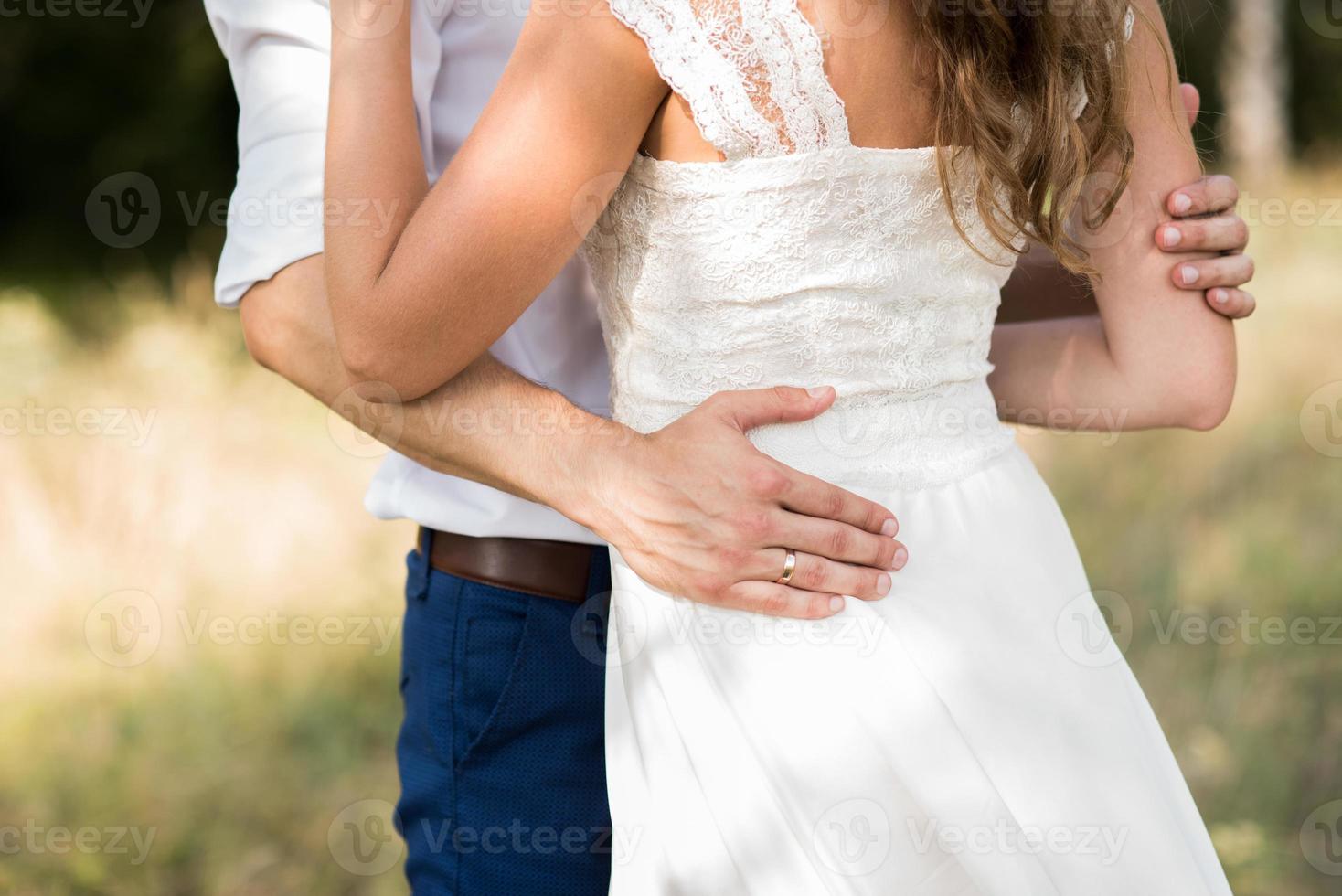 la sposa abbraccia lo sposo foto