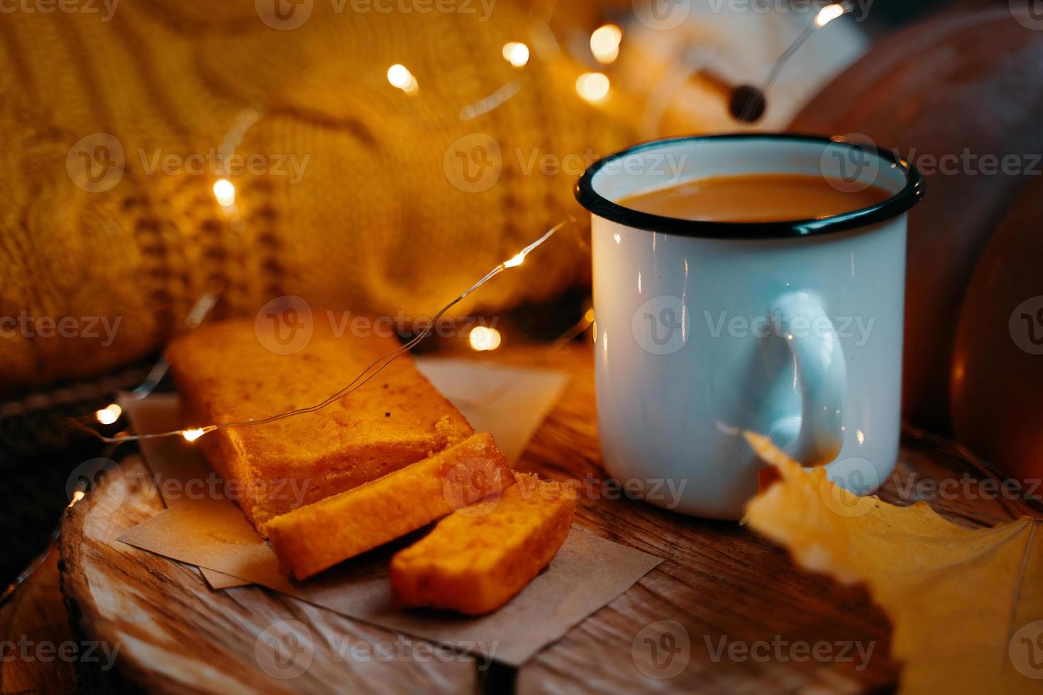 succo di zucca, torta di carote su vassoio di legno e maglione lavorato a maglia arancione. foto