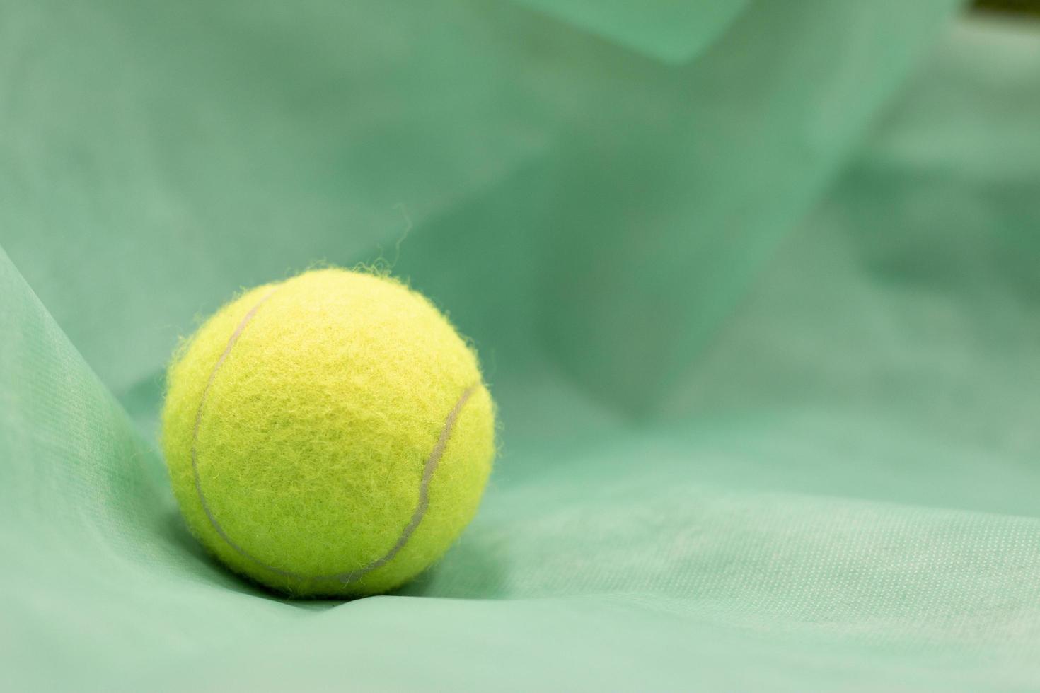 la pallina da tennis è su sfondo verde foto