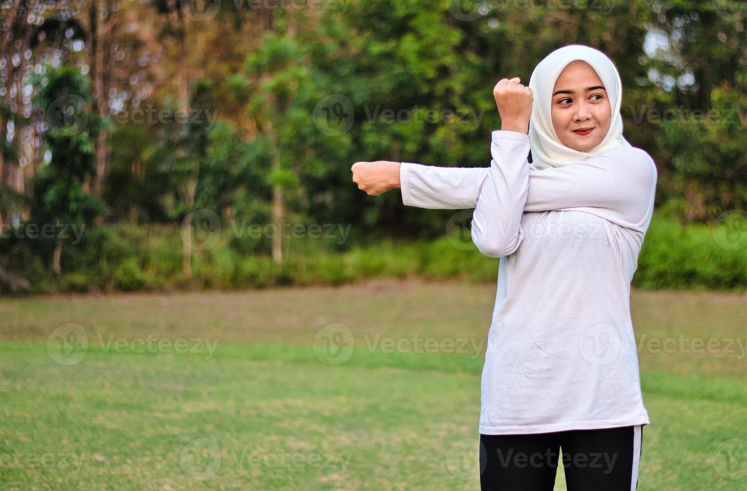 giovane donna musulmana che fa stretching muscolare prima di fare movimenti yoga foto