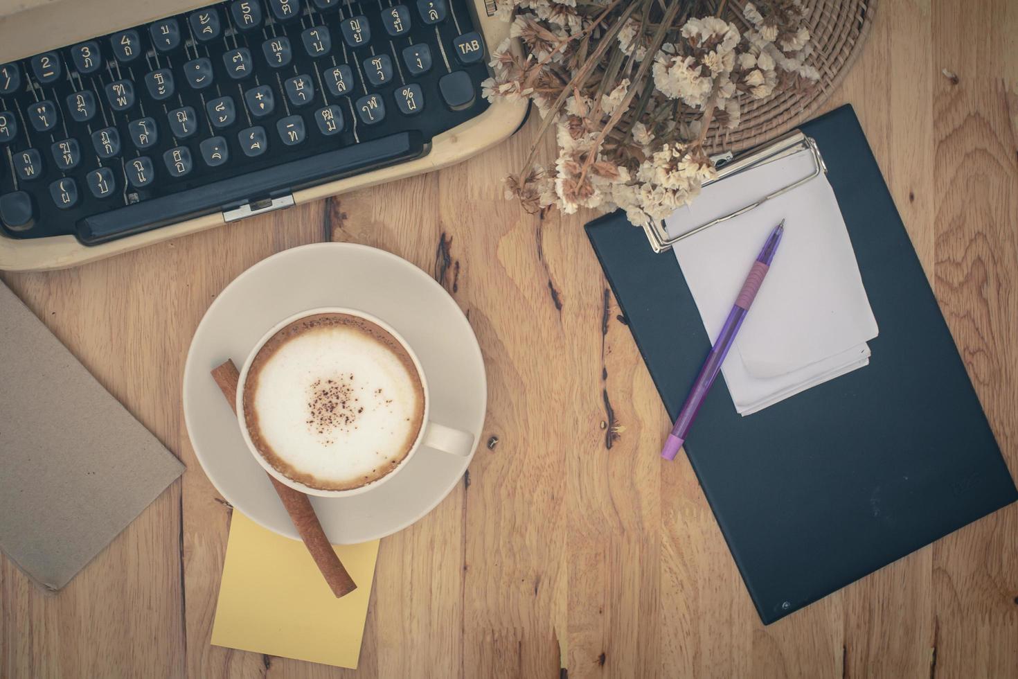 macchine da scrivere vintage e tazza di caffè sul tavolo di legno foto