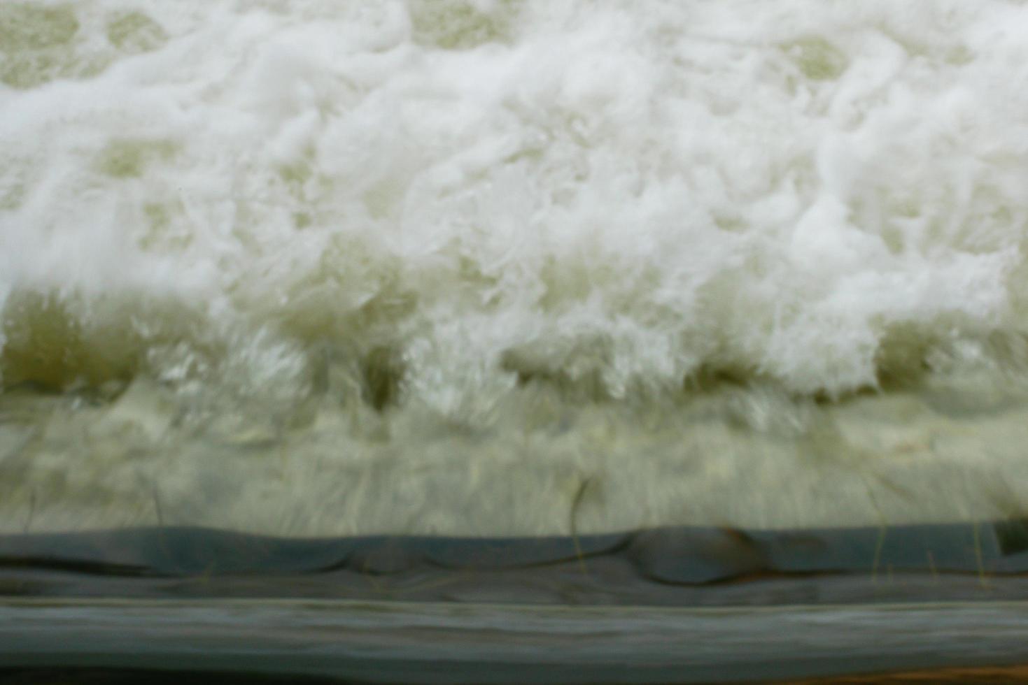 sfocatura del movimento di potenti onde d'acqua con schiuma bianca che si alza foto