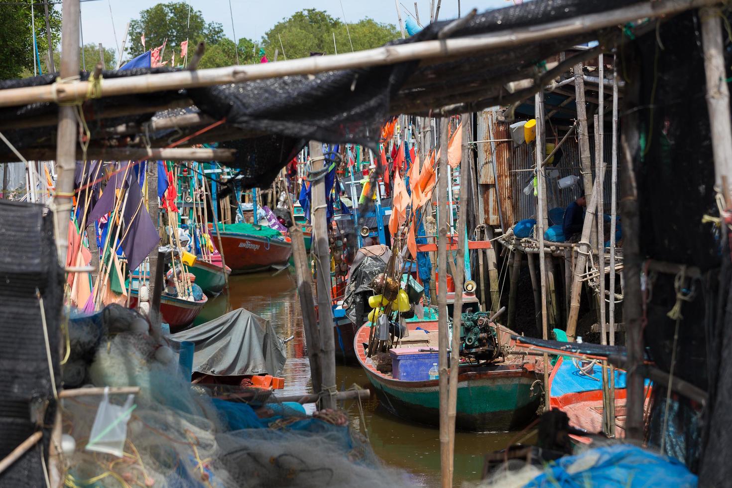 piccole barche da pesca tailandesi hanno attraccato al villaggio di pescatori durante il giorno foto