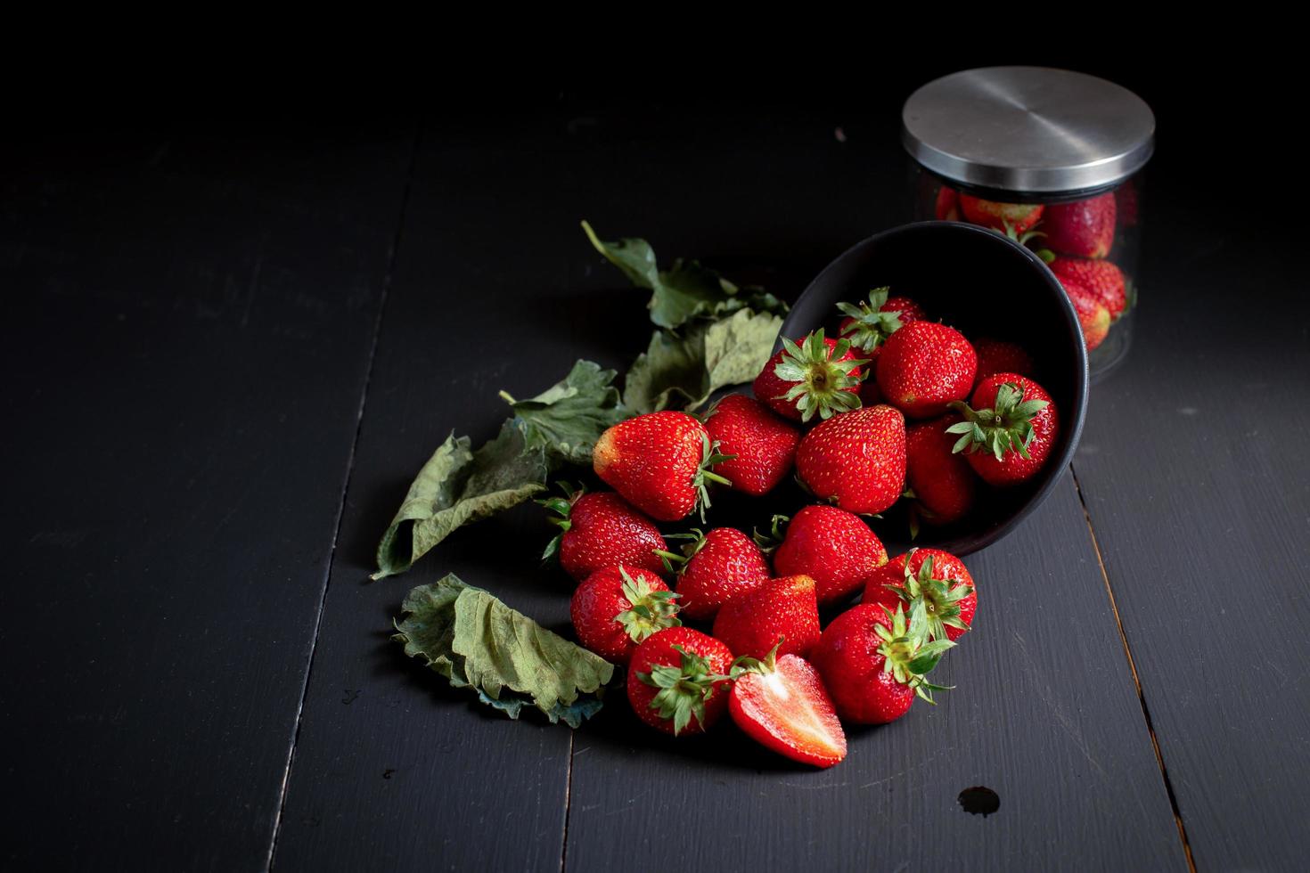 fragole rosse mature sul tavolo di legno nero foto