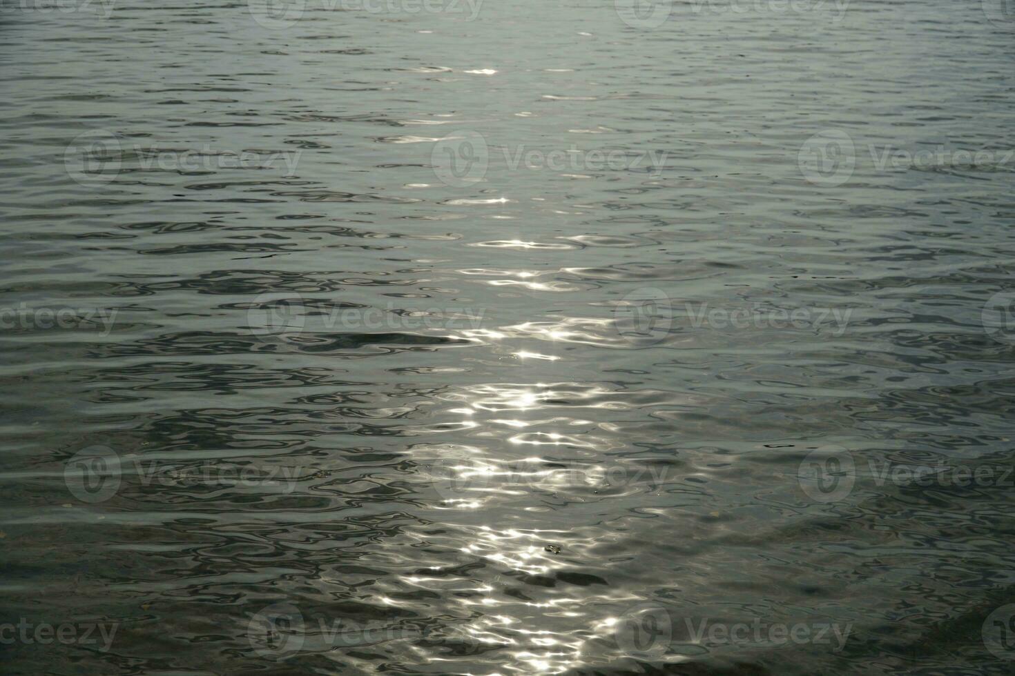 sole riflettendo nel acqua superficie foto