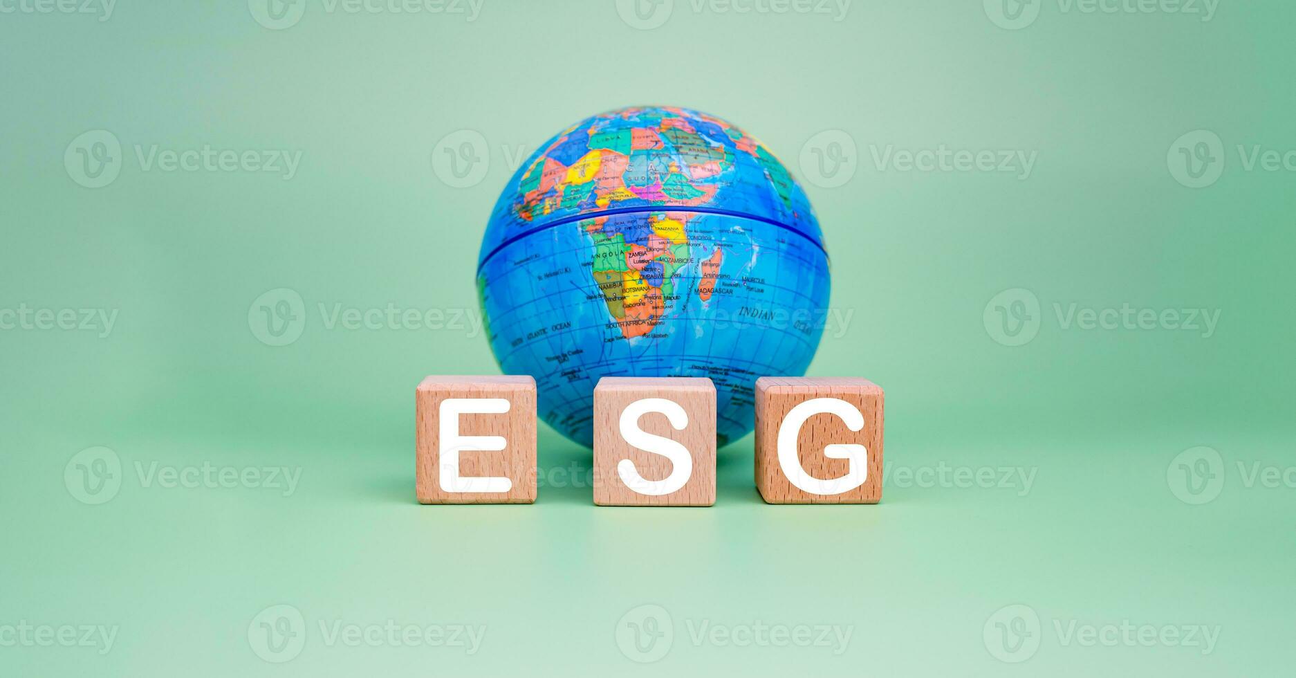 esg concetto per ambiente, società e governo nel sostenibile. attività commerciale responsabile ambientale. di legno blocchi con esg lettere stampato su loro e un' modello di il terra su un' verde sfondo. foto