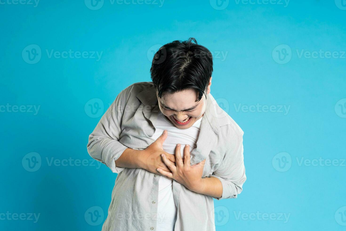 Immagine di asiatico uomo avendo Salute i problemi, isolato su blu sfondo foto