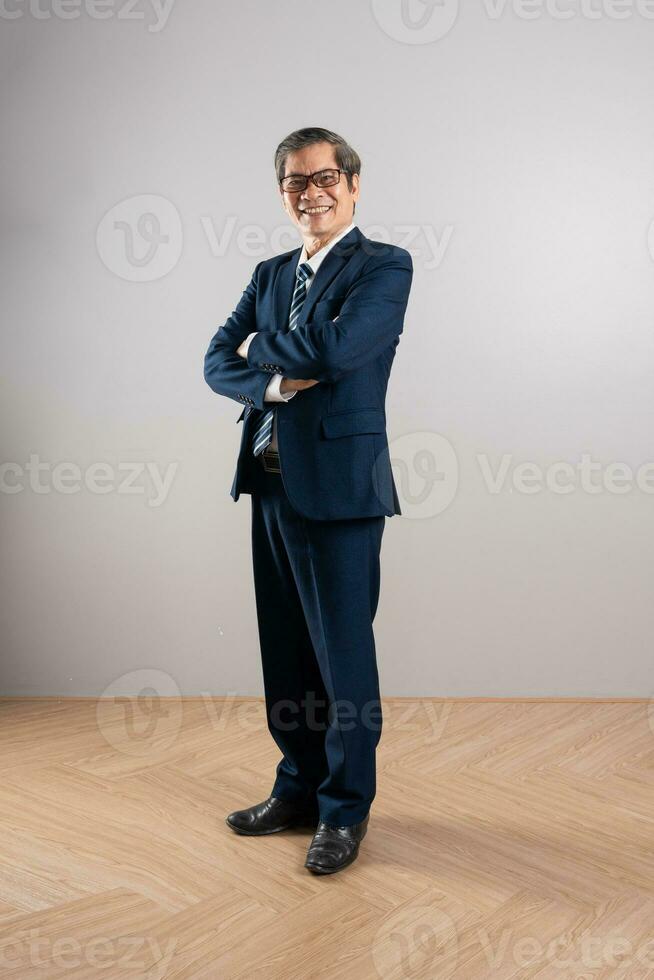 ritratto di un anziano asiatico uomo d'affari, in posa su un' blu sfondo foto
