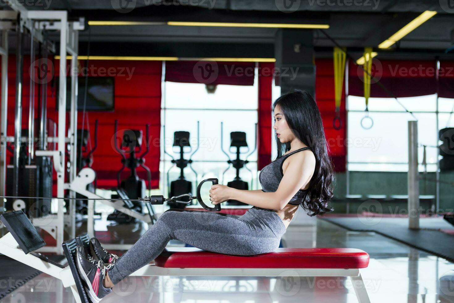 fitness asiatico donne l'esecuzione fare esercizi formazione con canottaggio macchina nel sport Palestra interno e fitness Salute club con gli sport esercizio attrezzatura palestra. foto