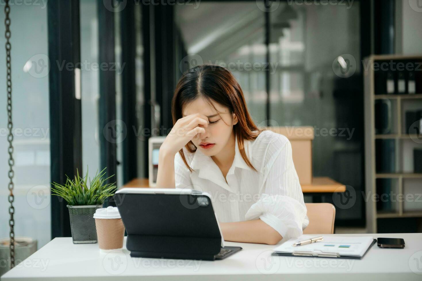 frustrato giovane donna d'affari Lavorando su un' il computer portatile computer seduta a il suo Lavorando posto nel ufficio foto