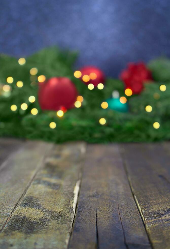 sfocato Natale, nuovo anno sfondo con sfocato abete albero rami, giocattoli, sfocato luci. di legno tavola con piccolo chiaro spazio per pubblicizzare Prodotto. verticale. copia spazio foto