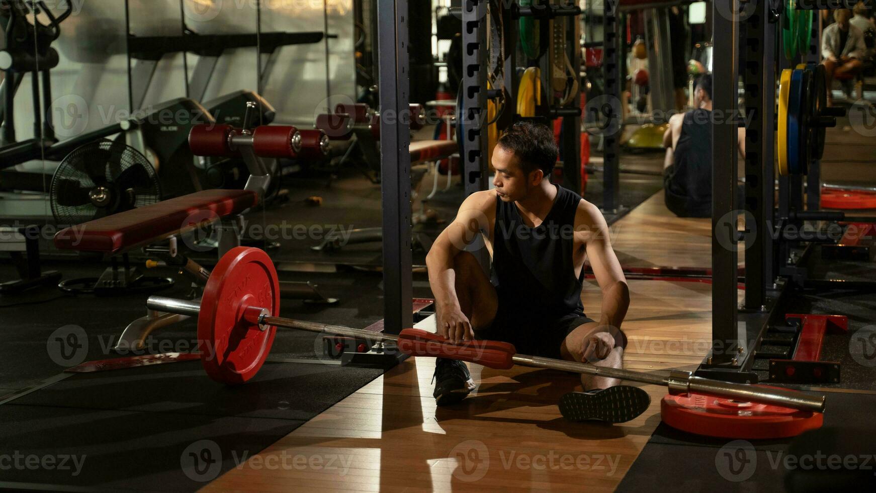 giovane asiatico uomo stanco dopo sollevamento manubrio nel un' palestra. foto