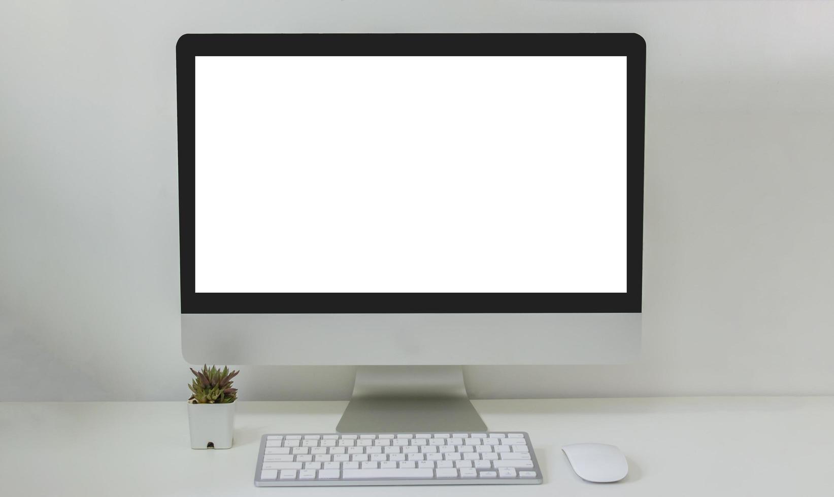 computer desktop mock up e mouse cactus bianco schermo vuoto sul tavolo. utilizzato per pubblicizzare il testo sullo schermo del computer foto
