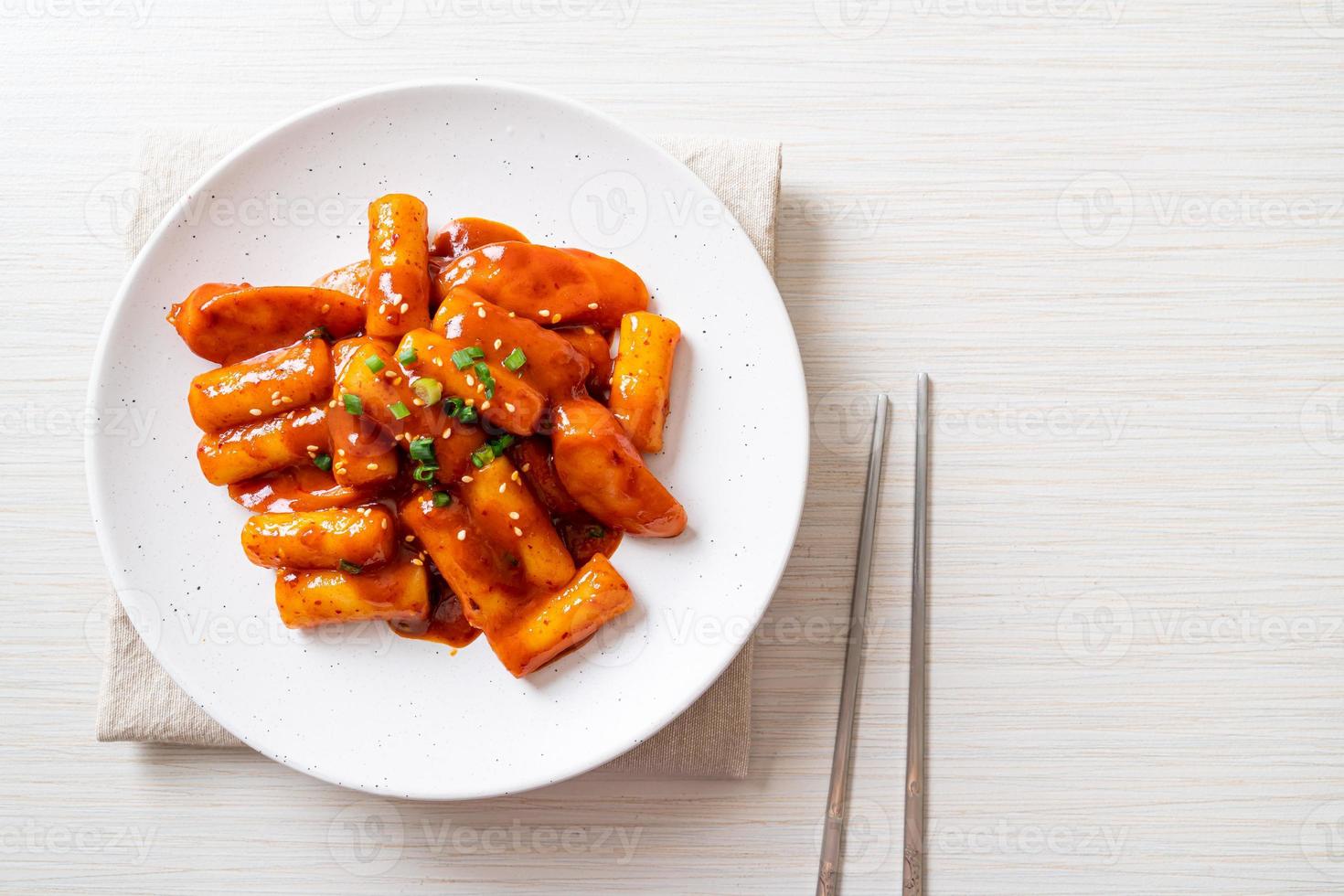 Stecco di torta di riso coreano con salsiccia in salsa piccante - tteokbokki foto