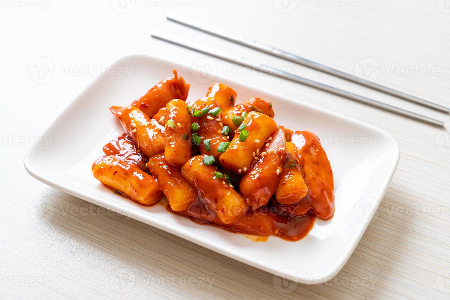 Stecco di torta di riso coreano con salsiccia in salsa piccante - tteokbokki foto