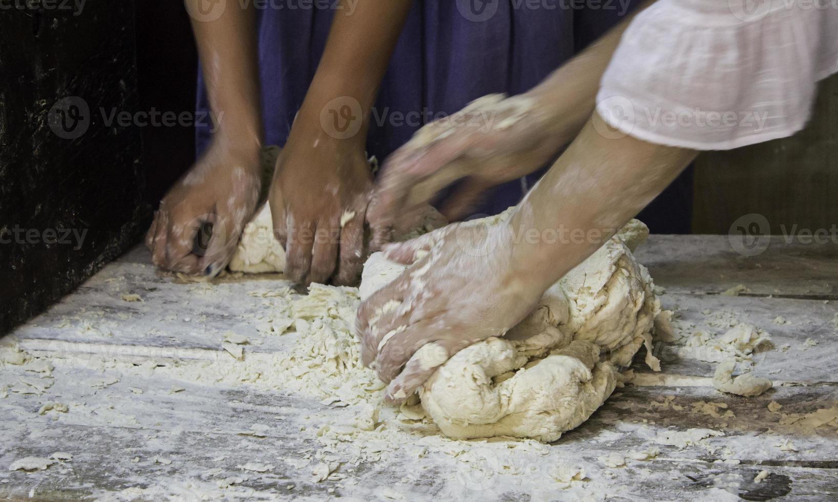 panettieri che impastano la pasta del pane in modo tradizionale foto