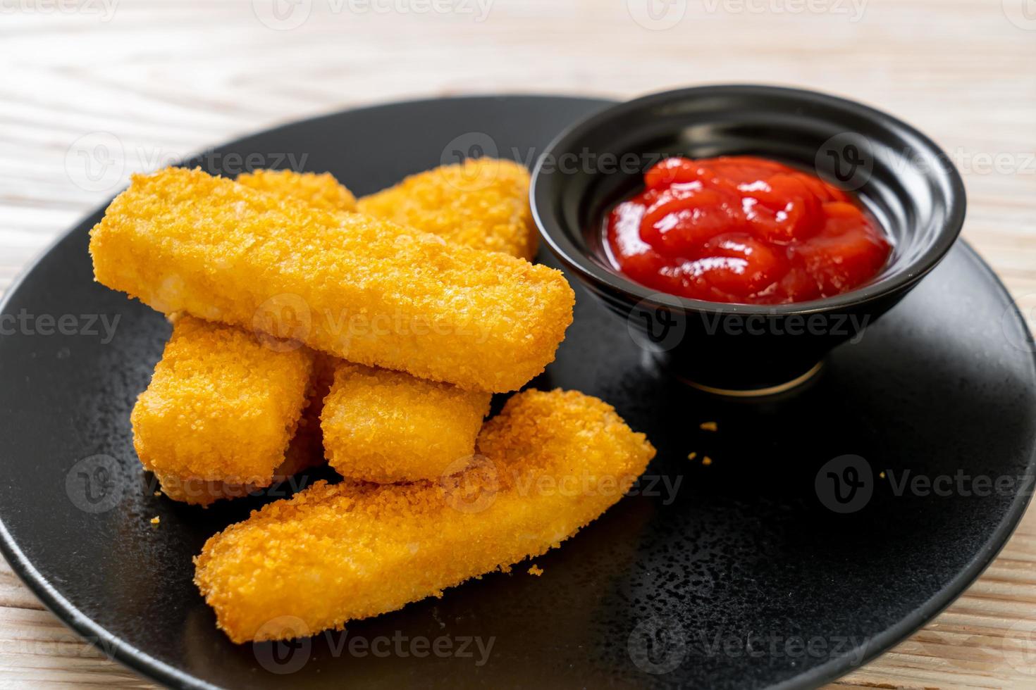 bastoncini di pesce fritti croccanti con pangrattato serviti alla piastra con ketchup foto