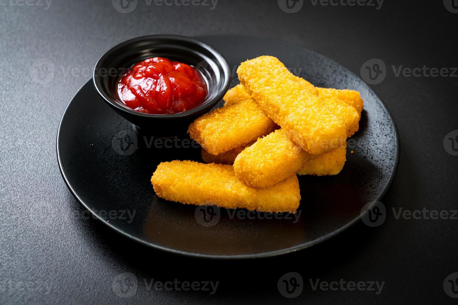 bastoncini di pesce fritti croccanti con pangrattato serviti alla piastra con ketchup foto
