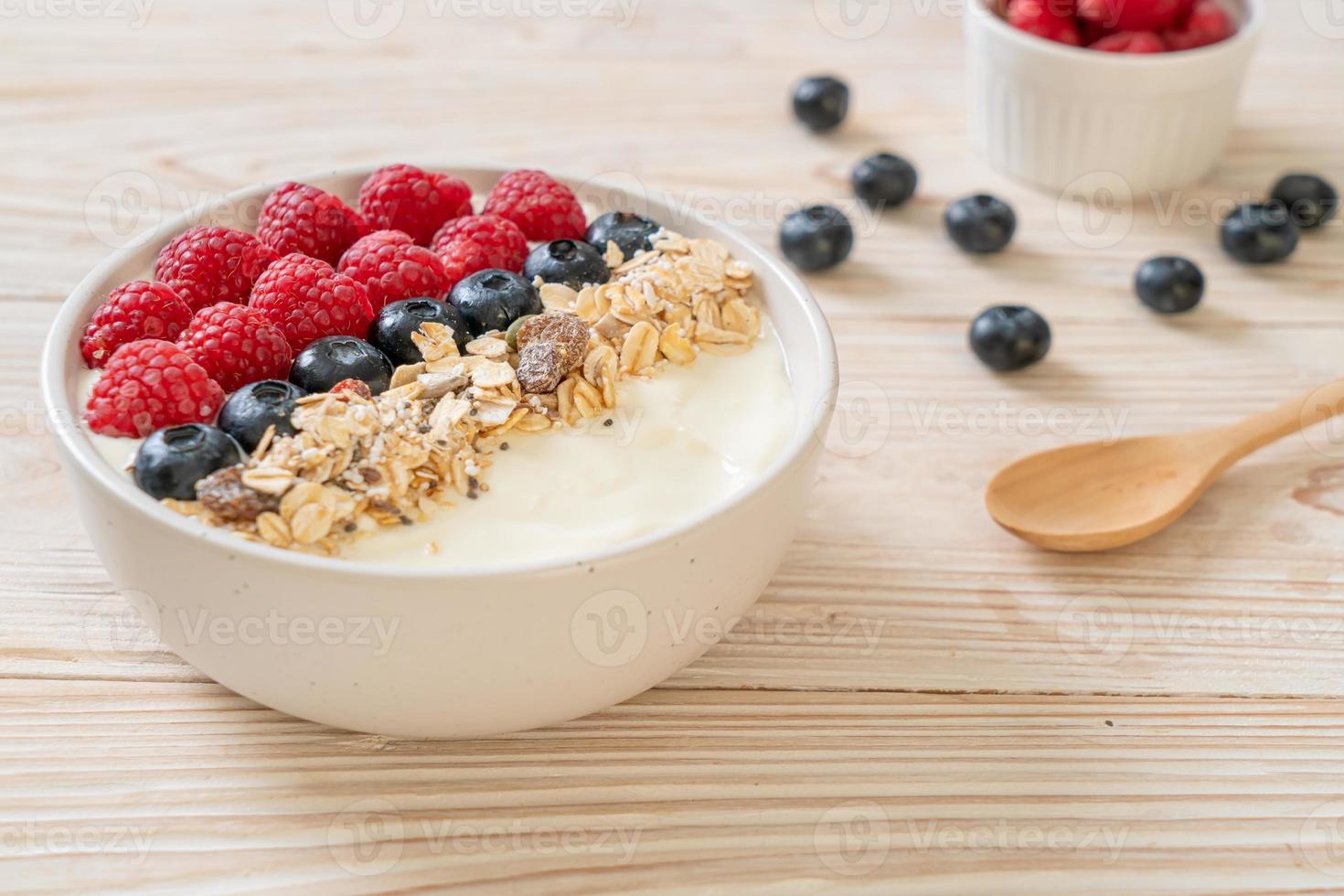 ciotola di yogurt fatta in casa con lampone, mirtillo e muesli - stile alimentare sano foto