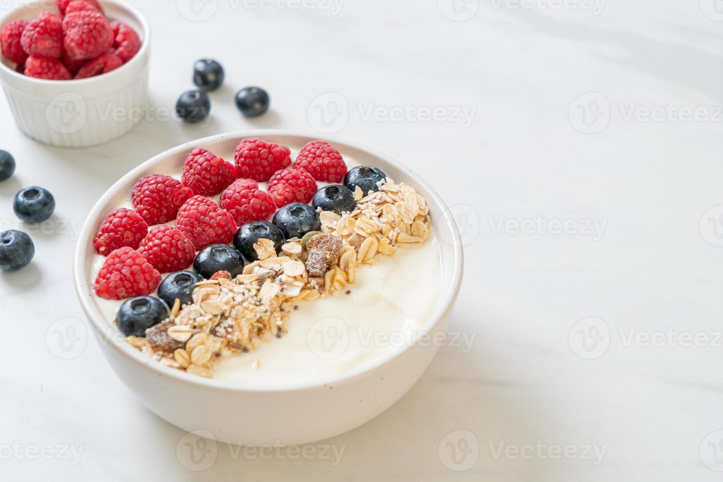 ciotola di yogurt fatta in casa con lampone, mirtillo e muesli - stile alimentare sano foto