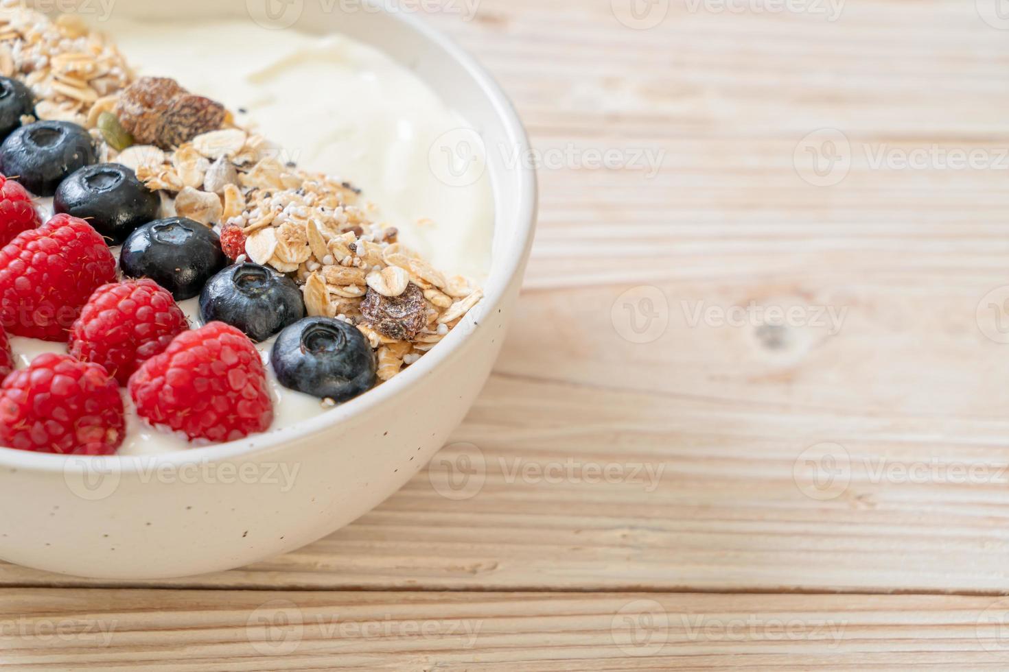 ciotola di yogurt fatta in casa con lampone, mirtillo e muesli - stile alimentare sano foto