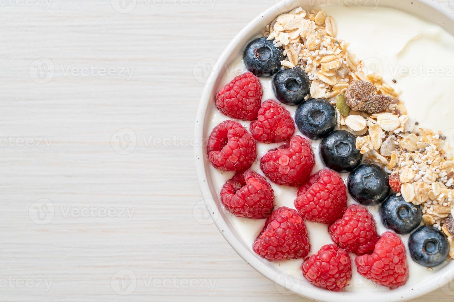 ciotola di yogurt fatta in casa con lampone, mirtillo e muesli - stile alimentare sano foto