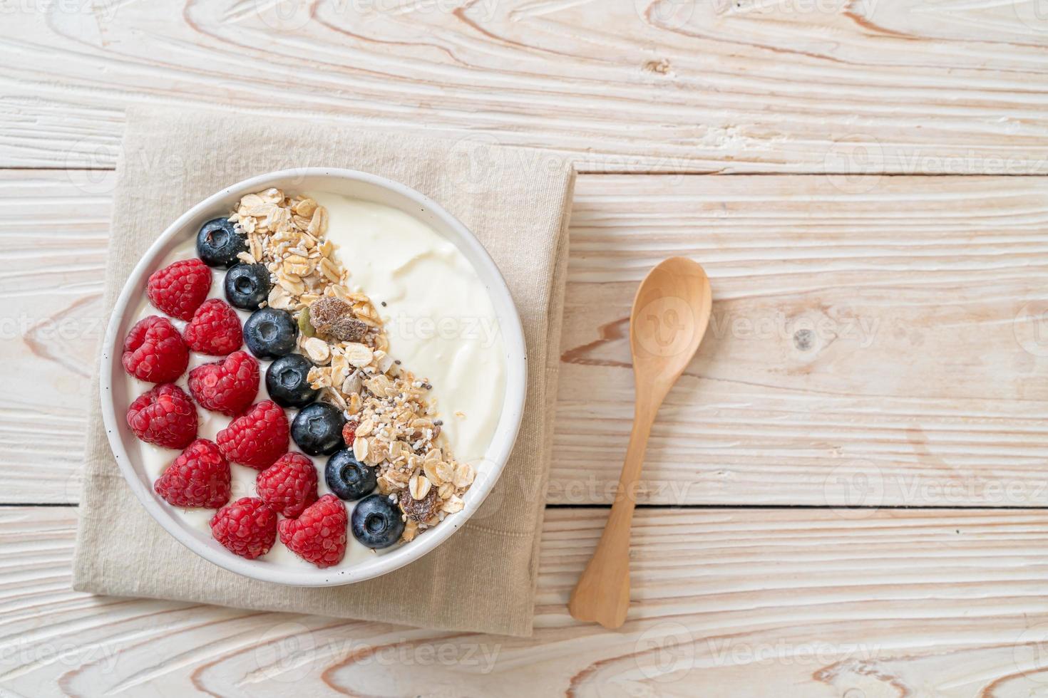 ciotola di yogurt fatta in casa con lampone, mirtillo e muesli - stile alimentare sano foto