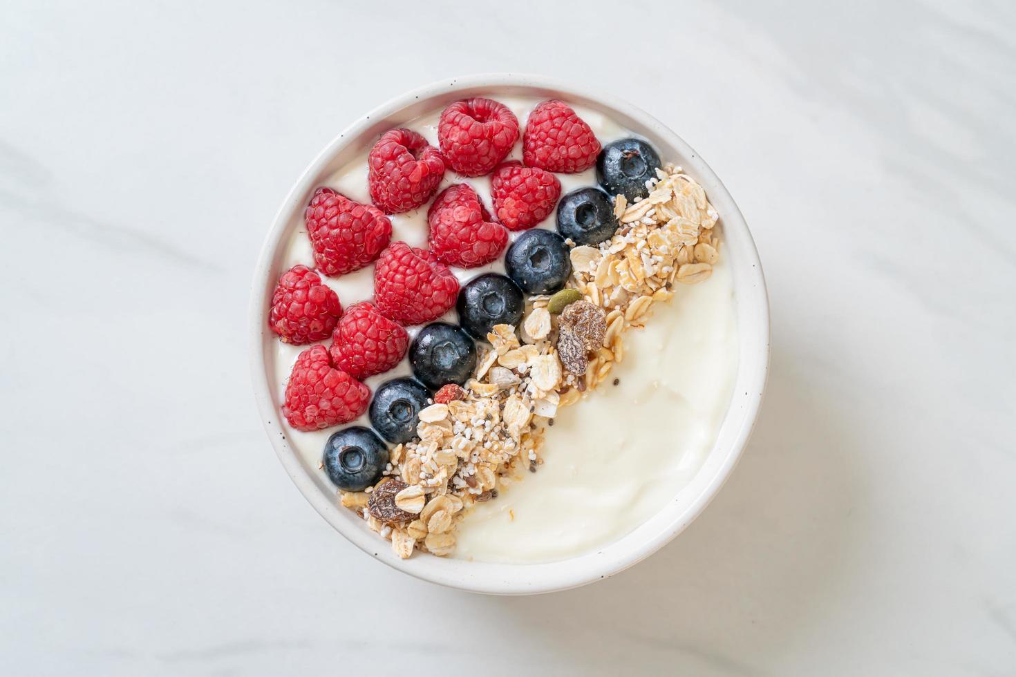 ciotola di yogurt fatta in casa con lampone, mirtillo e muesli - stile alimentare sano foto