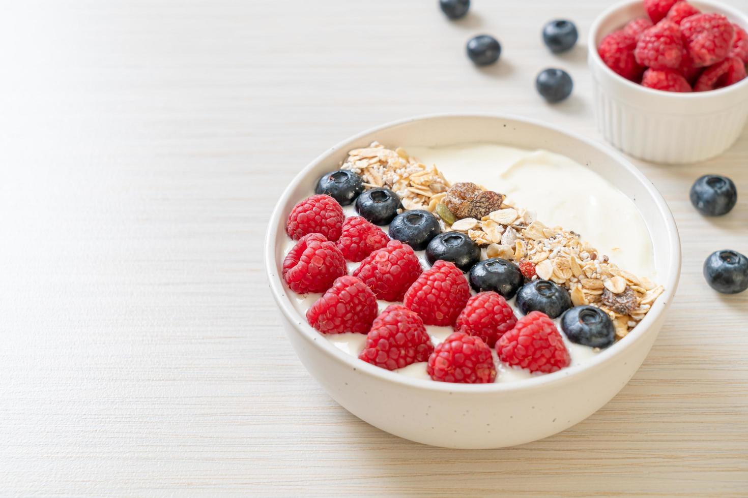 ciotola di yogurt fatta in casa con lampone, mirtillo e muesli - stile alimentare sano foto