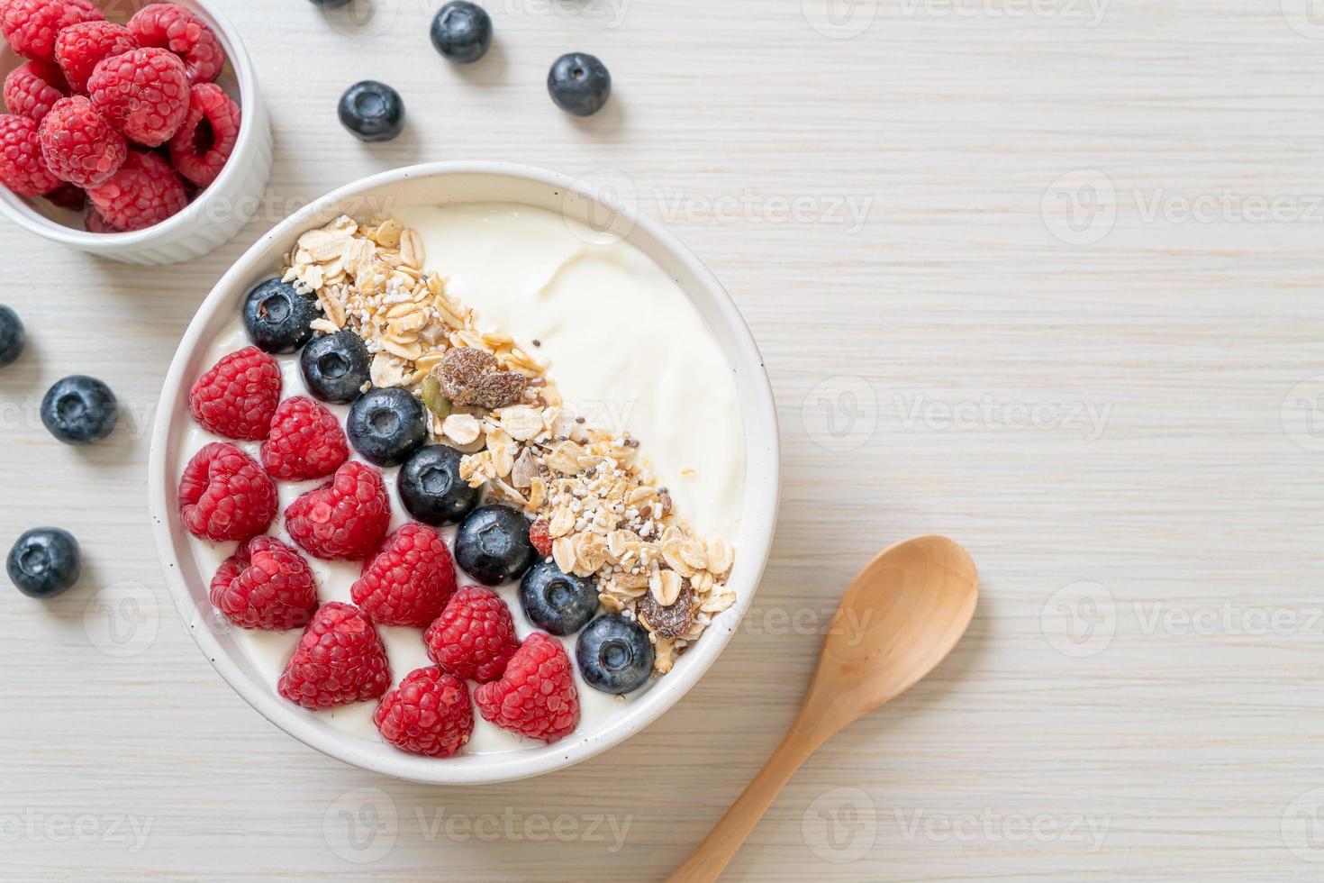 ciotola di yogurt fatta in casa con lampone, mirtillo e muesli - stile alimentare sano foto