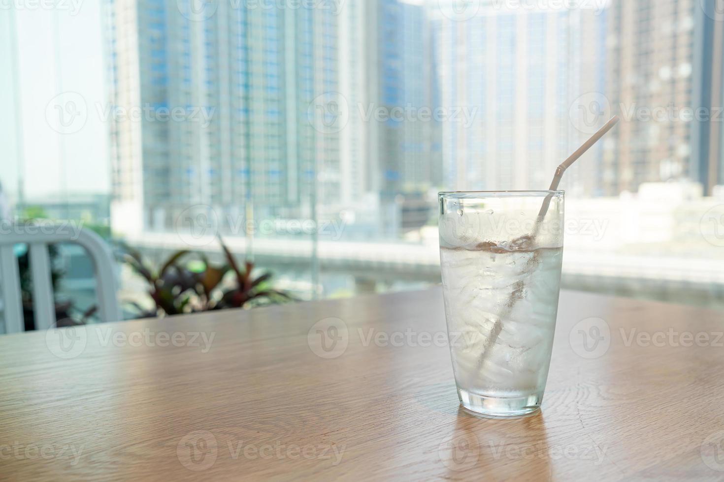 bicchiere d'acqua con ghiaccio sul tavolo foto