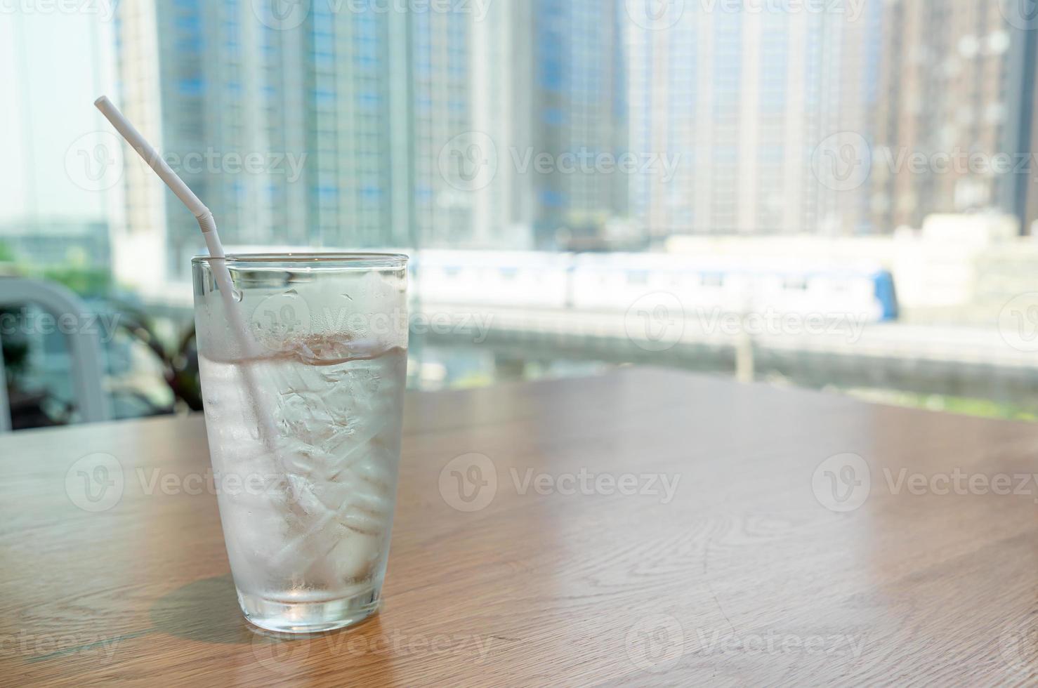 bicchiere d'acqua con ghiaccio sul tavolo foto