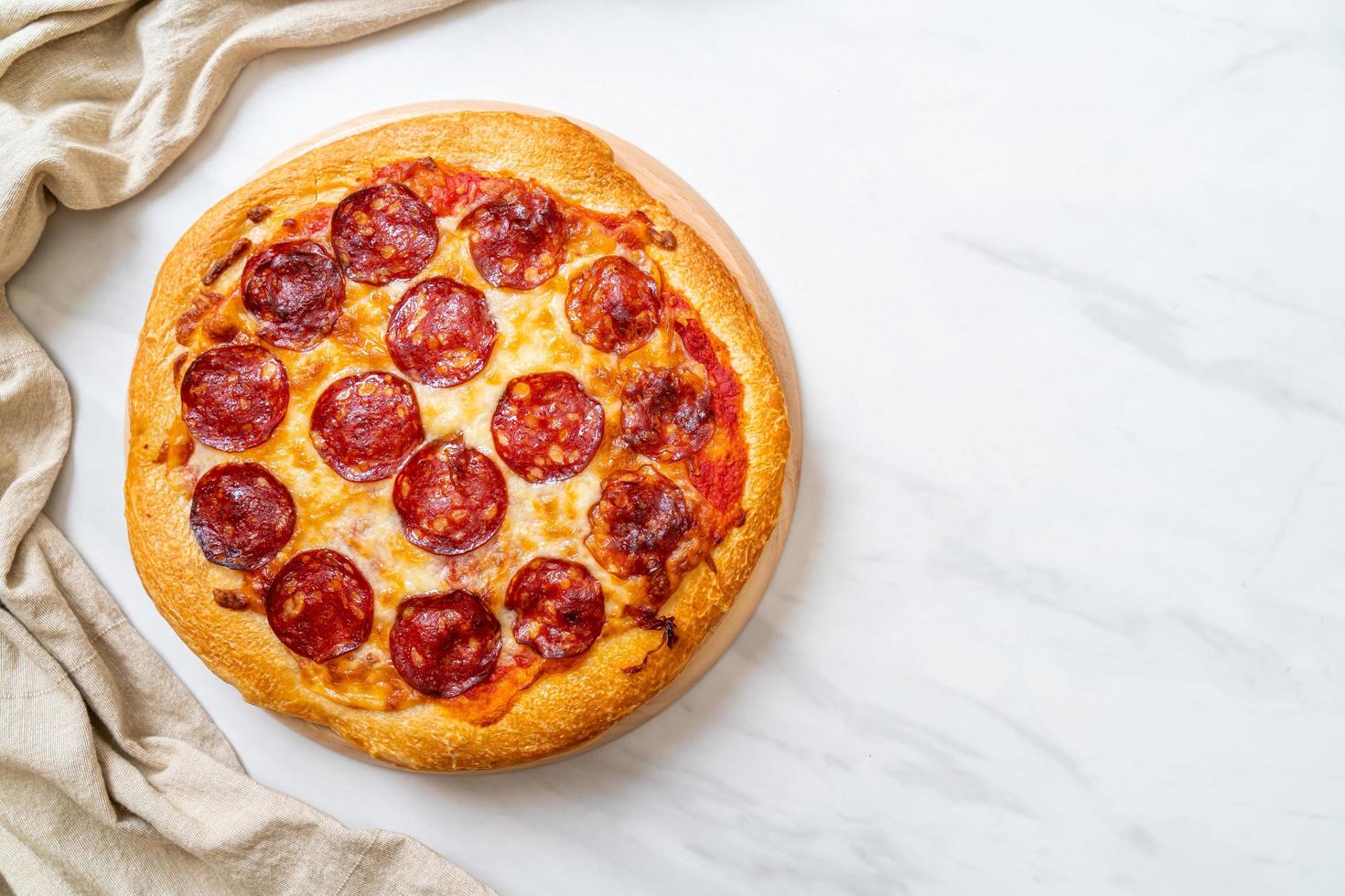 pizza ai peperoni su vassoio di legno - stile alimentare italiano foto