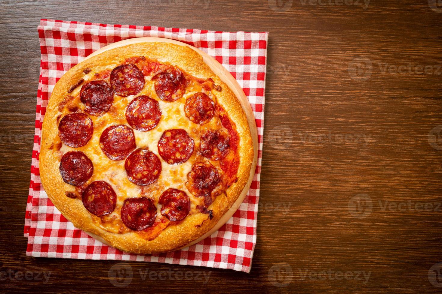 pizza ai peperoni su vassoio di legno - stile alimentare italiano foto