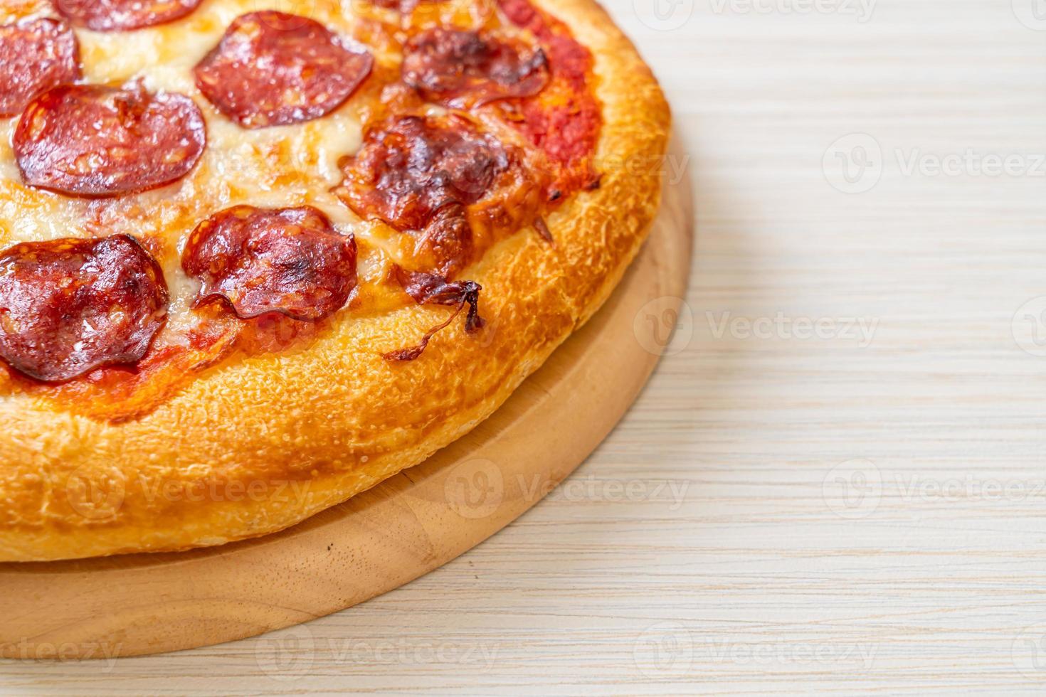 pizza ai peperoni su vassoio di legno foto