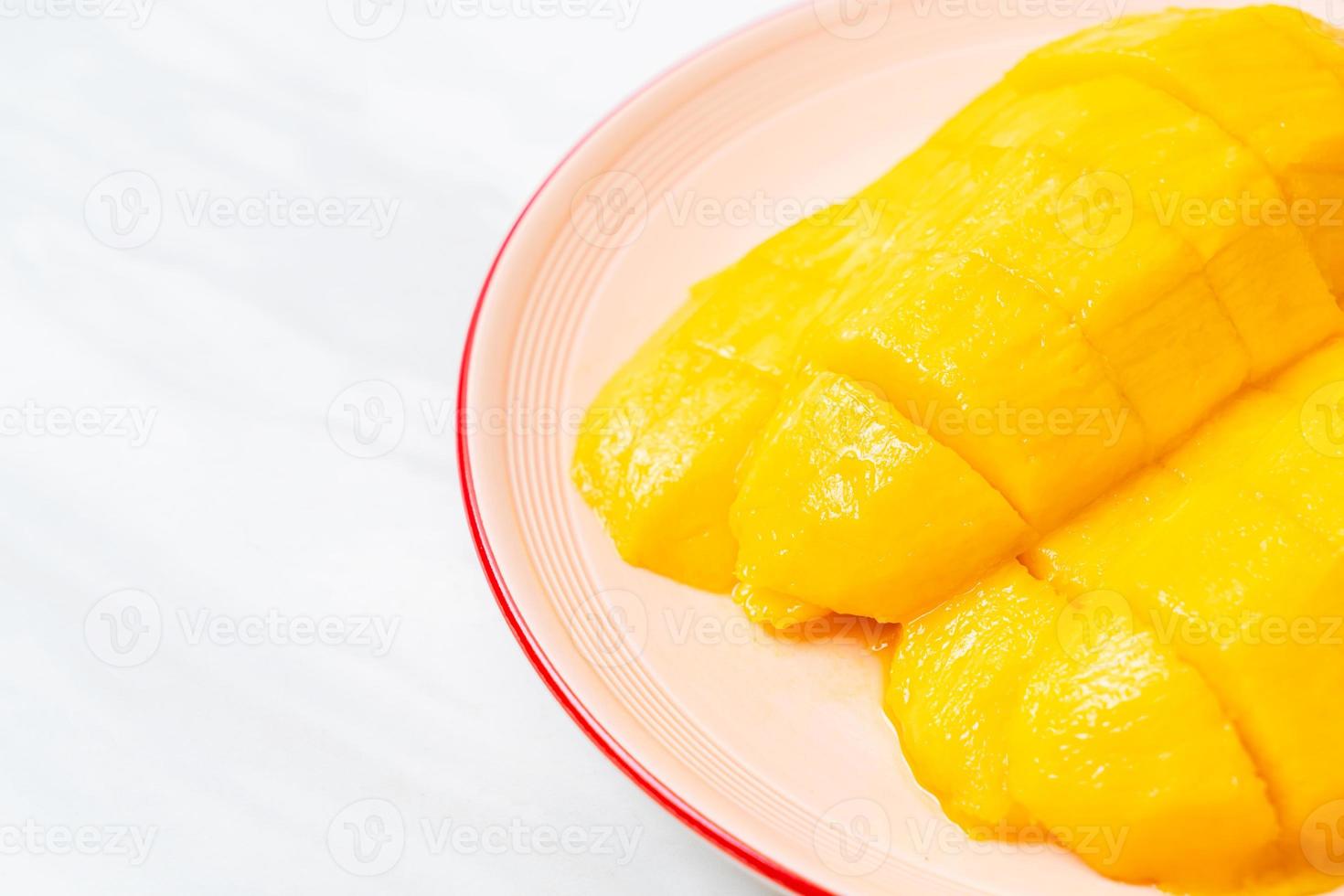 mango fresco e dorato affettato sul piatto foto