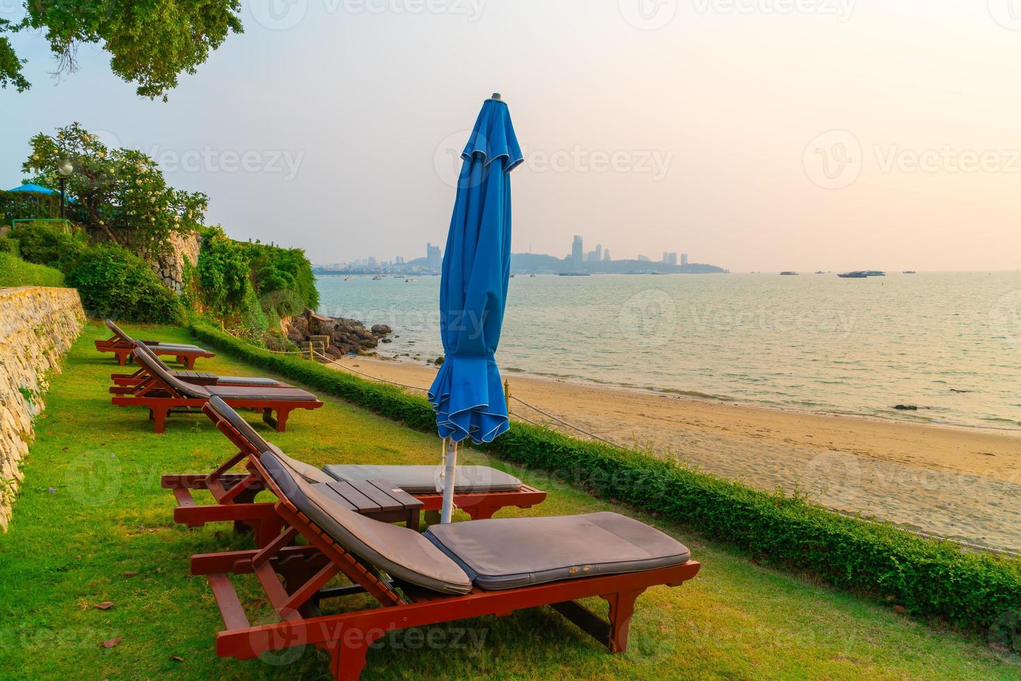 sedie a sdraio con sfondo mare spiaggia al tramonto a pattaya, thailandiaya foto