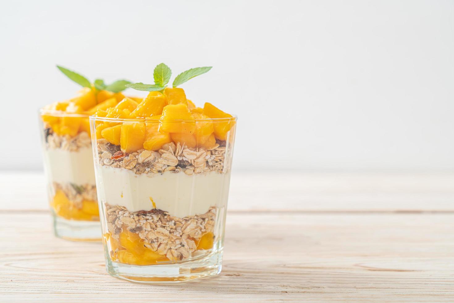 yogurt al mango fresco con muesli in vetro - stile di cibo sano foto